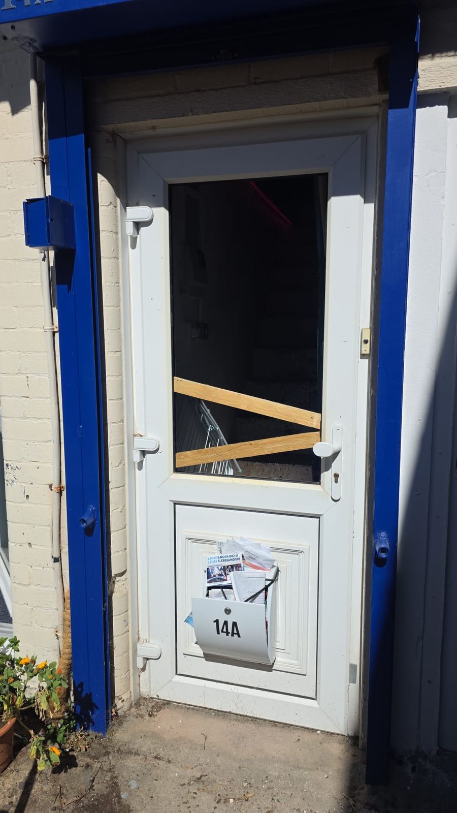 Smashed commercial door glass with temporary wood bracing — before board-up by LT Lockworks